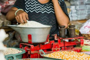 Woman touches white rice in a bowl